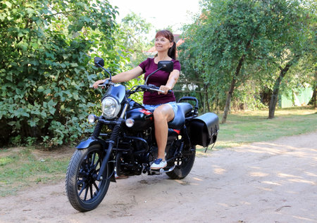 woman driving a motorcycle outside the cityの写真素材