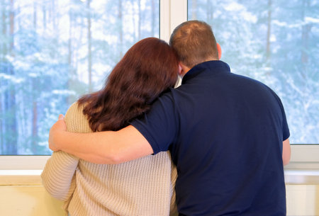 couple at the window in winterの写真素材