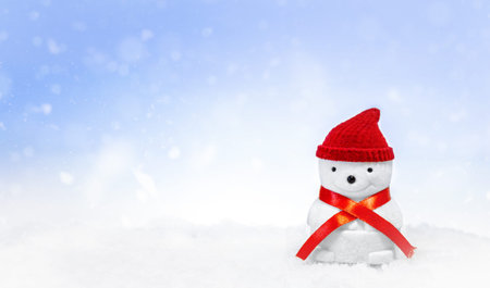 Snowman in a red hat and with a red scarf on the snowの写真素材