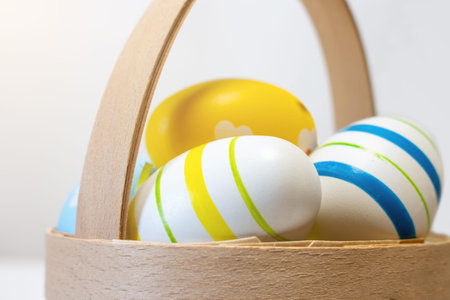 blue and yellow easter eggs in a basket close-up