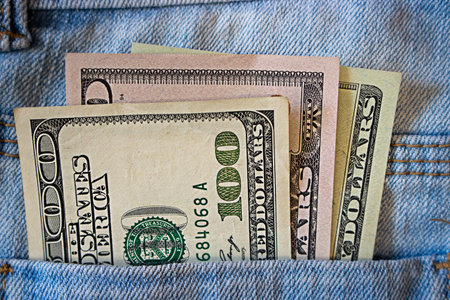 Banknotes sticking out of jeans pocket
