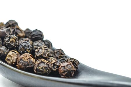 spoon full of black peppercornの写真素材