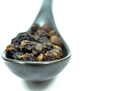 spoon full of black peppercornの写真素材