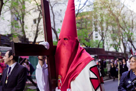 The popular traditional Spanish catholic march in Madrid wearing the nazareno semana santa clothes and symbols, A religious procession celebrating in easter Holy Week. Interesting to travel and seeのeditorial素材