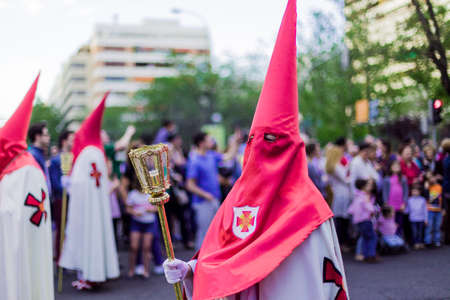 The popular traditional Spanish catholic march in Madrid wearing the nazareno semana santa clothes and symbols, A religious procession celebrating in easter Holy Week. Interesting to travel and seeのeditorial素材