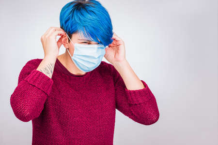 how to put a COVID-19 mask. Woman with Coronavirus breath maskの写真素材