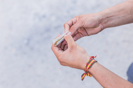 Young doing a marijuana joint. Close up smoke cannabis as a concept of alternative medicine and...