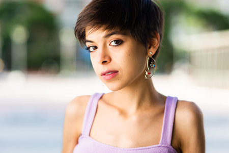 Hispanic young Tomboy bisexual woman headshot portrait. Short hair lesbian lifestyle