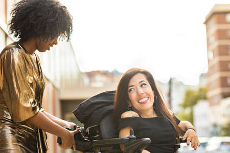 Handicapped woman on a motor wheelchair celebrate New Year Eve Party with friends. Dysplasiaの写真素材