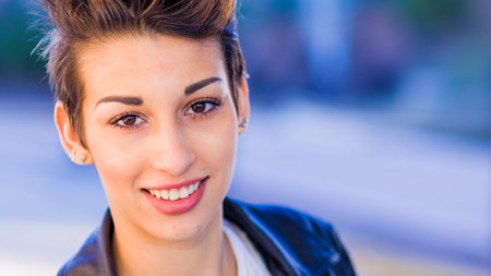 headshot froma a yooung hispanic female. Beautiful woman with an ambiguous hairsyling