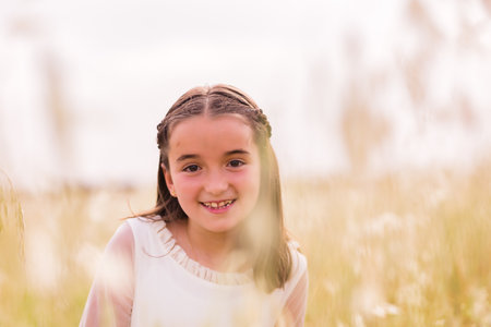 communion girl. catholic religion child celebration hispanic female portrait. summer and springの写真素材