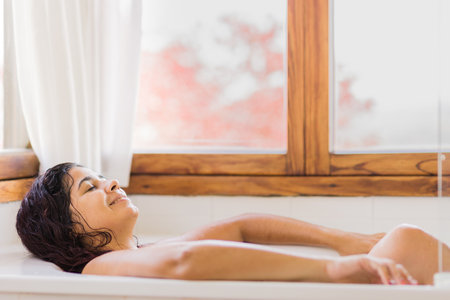 Latin mid woman bathing happy and smile. fun and enjoyment at the tub. Venezuelan person bodycareの写真素材