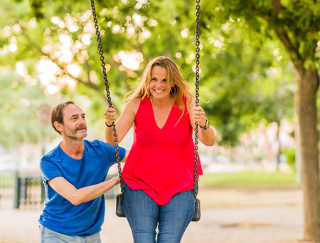 married mature 50s couple enjoy happy in playground swing. Seniors freedom love and happinessの写真素材