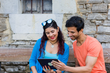 mixed race couple together in Villanueva Asturias using tablet technology outdoors on holydayの写真素材