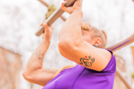 Calisthenics pull- up back exercise for cross fitness workout. Hispanic mid sportswoman athletic