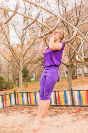 Calisthenics pull- up back exercise for cross fitness workout. Hispanic mid sportswoman athletic