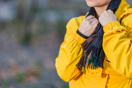 Winter woman on cold weather. Sore throat scarf detail Unrecognizable mid Hispanic. Yellow raincoatの写真素材