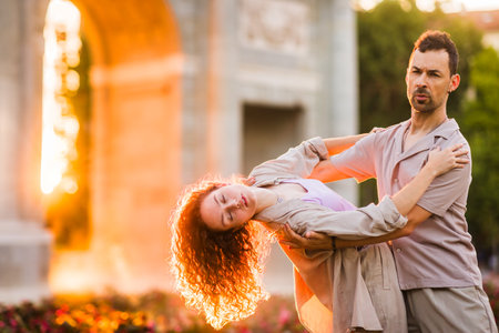 Dancers performing swing dance at puerta de alcala in madrid at sunsetの写真素材