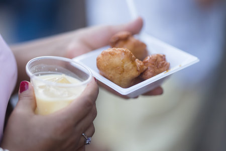 Woman holding bunuelos and horchata during hispanic heritage celebration. Dia de la hispanidadの写真素材