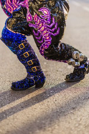 Dancer wearing elaborate costume and boots is performing during hispanicity day parade.