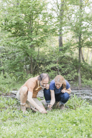 Biologists examining plants with magnifying glass in retiro park, madrid