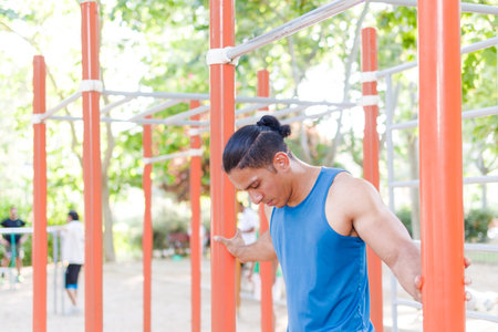 Venezuelan Latin man athlete training with determination in calisthenics parkの写真素材