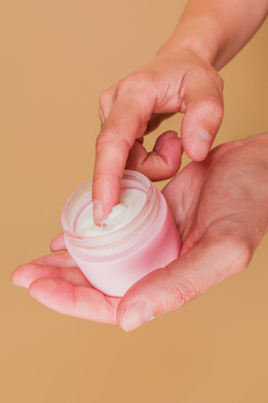 Hands applying hydrating cream, embracing skin care routineの写真素材
