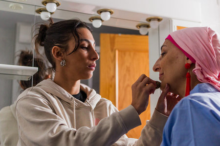 Daughter applying makeup helping mother feel beautiful