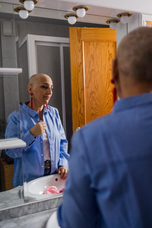 Woman with cancer embracing beauty in mirrorの写真素材