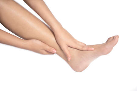 Women she is taking care of her feet. Isolated white backgroundの写真素材