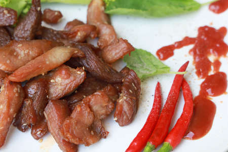 Fried pork and red chili on plateの写真素材