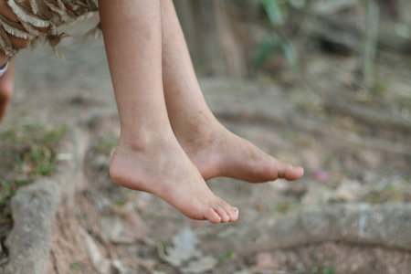Feet of a girl on a tree in the forest, close-upの写真素材