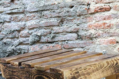 Vintage wooden floor with old red brick cement wall, warm and textured settingの写真素材