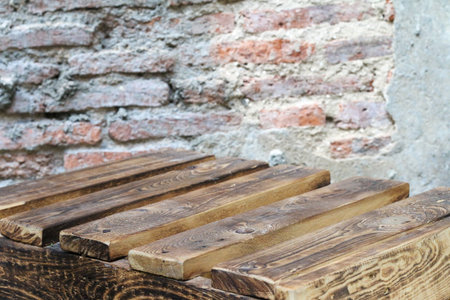 Antique wooden floorboards and rough red brick cement wall, timeless settingの写真素材