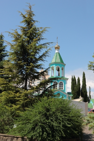 Upper part of a religious building with a dome and a cross in the settlement on the Black Sea coast の写真素材