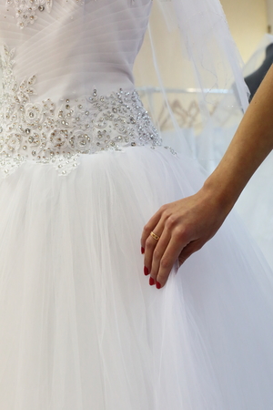 Woman trying to choose a wedding dress in wedding fashion store.の写真素材