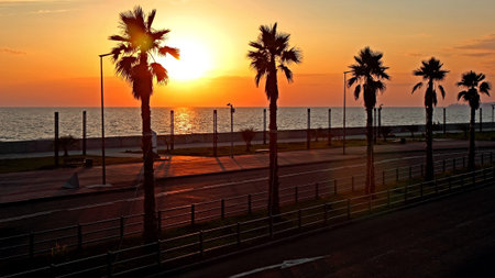 View of the solar disk on the shoreline of the resort town on the Black Sea.