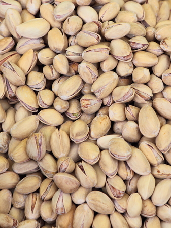 The large mass of dry salted nuts chaotically arranged on the table.の写真素材