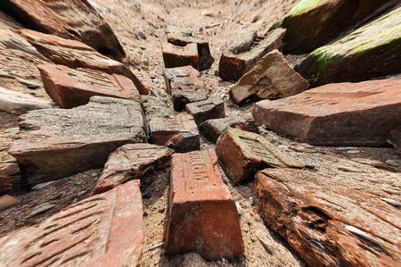 A pile of old broken bricks of different shapes and colors.の写真素材