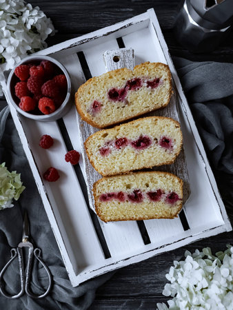 Raspberry cake with fresh raspberries on a white wooden tray