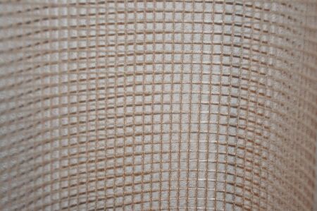 Beige net netting wavy detail curtains textile fabric canvas texture backgroundの写真素材