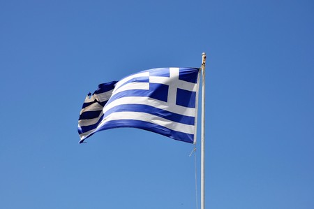 Greek flag on blue sky clear heaven blue backgroundの写真素材