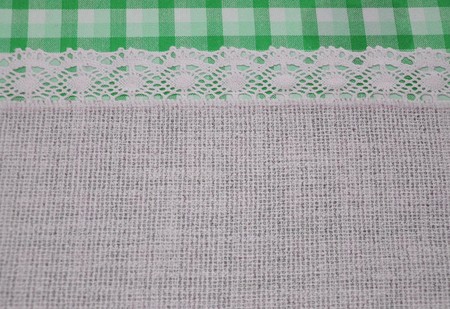 Linen cloth textile with lace lacy ribbon and border of green tartan pattern, vintage retro style background.の写真素材