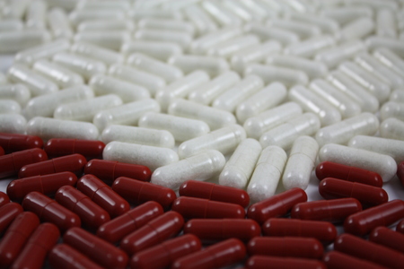 Two-colored medical capsules, tablets, pills, drugs, can be used as backgroundの写真素材