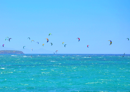 Many kiteboarding kite surfers in the distance near on Punda beach on Paros islandの写真素材