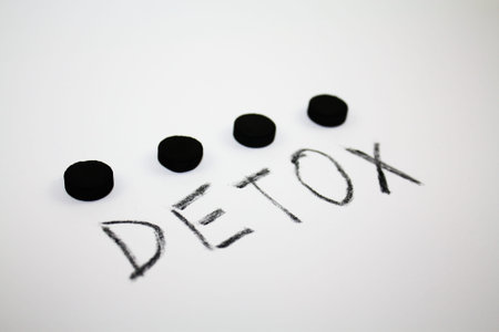 Activated charcoal round pills and inscription detox, helathy lifestyle carbon tablets concept
