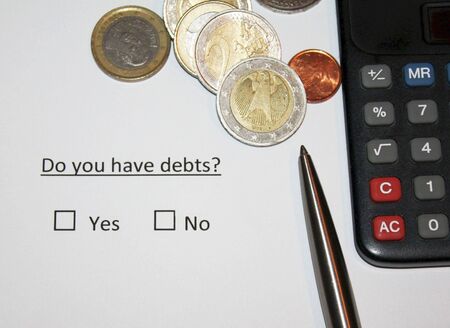 Do you have debts? Question on paper with yes or no box fot thick. European currency coins and calculator and pen.の写真素材