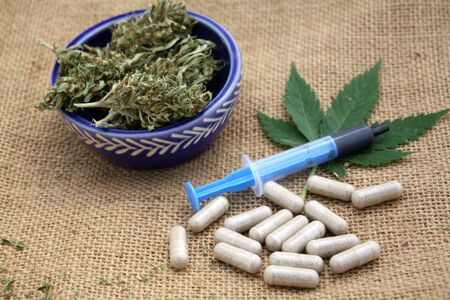 Hash oil phoenix tears medicine in little syringe with dry marijuana buds and cannabis leaf.の写真素材