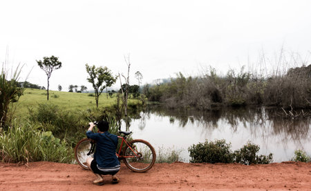 Boy with his bike at the muddy mess in the highlandの写真素材