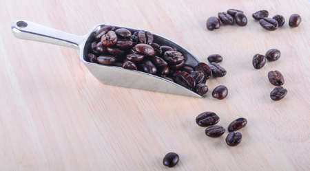 Wooden with coffee beans and coffee leaf on white background.の写真素材